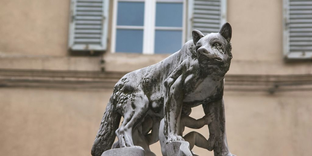 A statue of a dog on a rock in front of a building